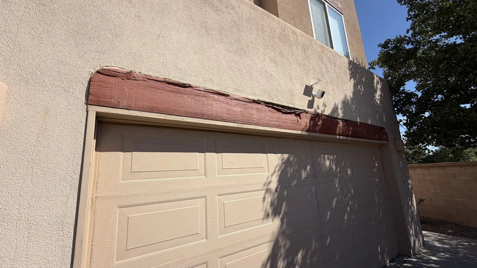 Close-up of a split, rotted wood garage door header