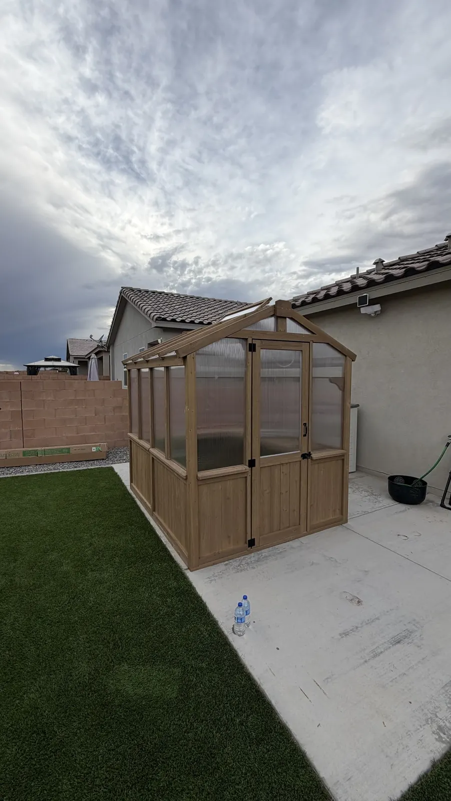 Finished cedar greenhouse on a backyard patio