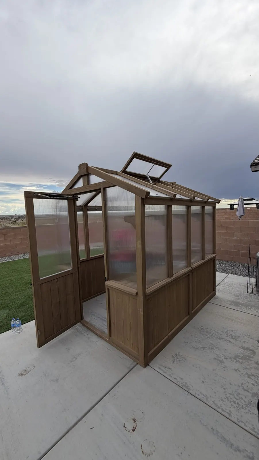 Cedar greenhouse with door and roof vent open