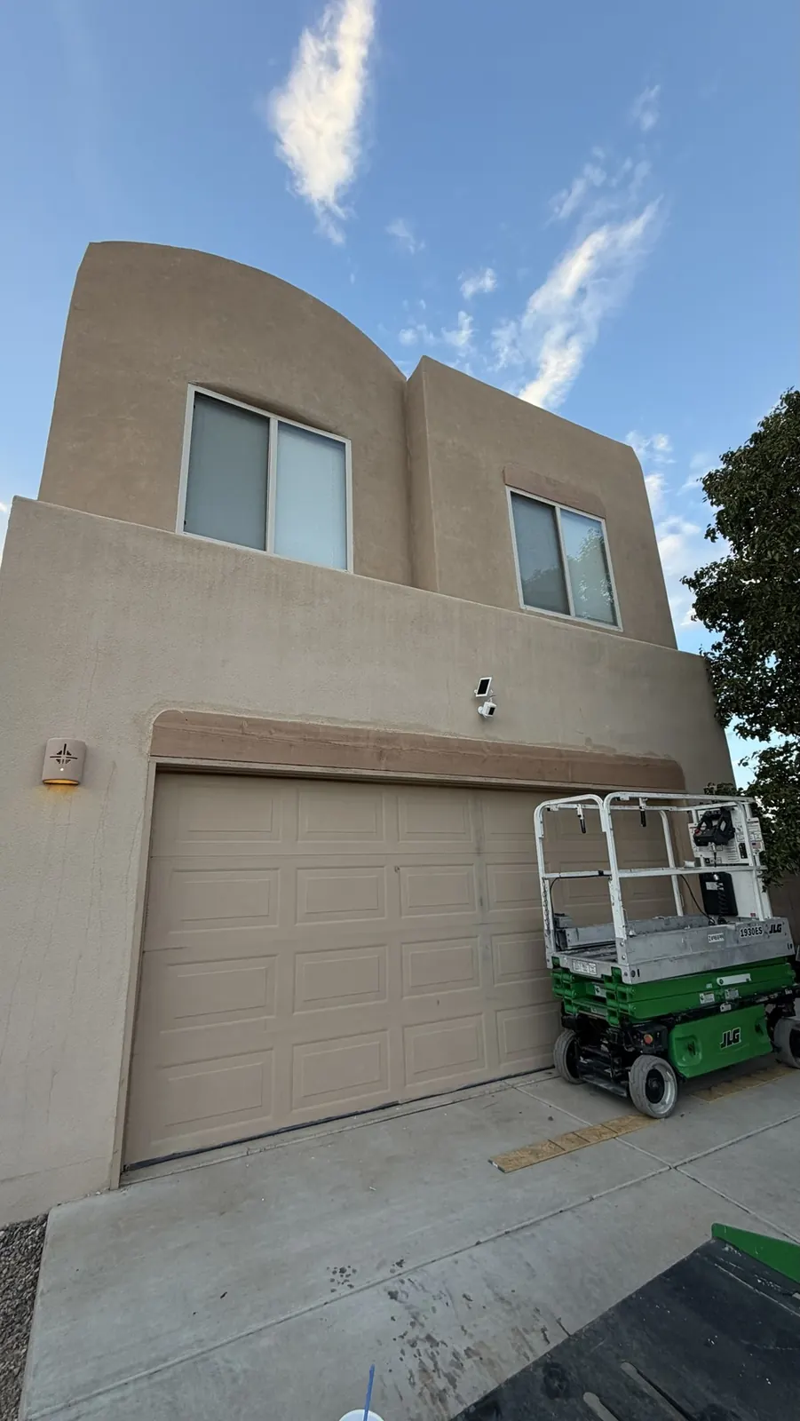 Garage header replaced and stucco finished, scissor lift on site