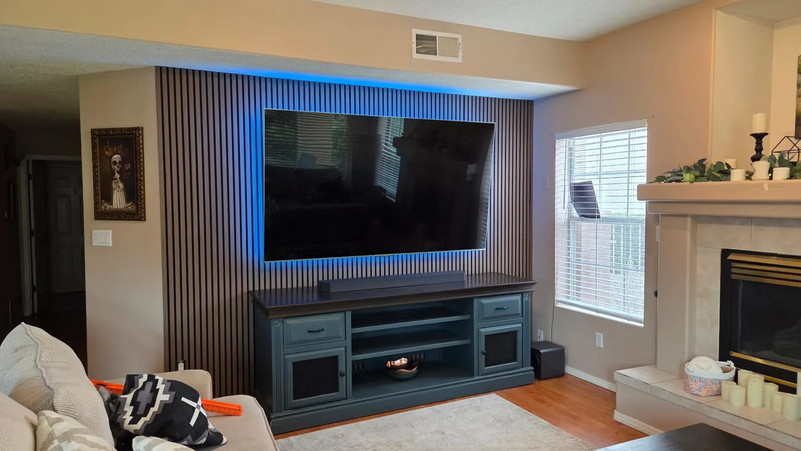 TV mounted on a slat accent wall with LED backlight in an Albuquerque living room